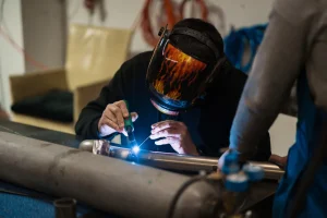 welder melakukan teknik pengelasan mig tig di workshop industri