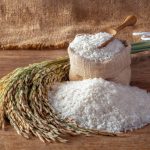 White rice (jasmine rice) in a sack on a wooden background